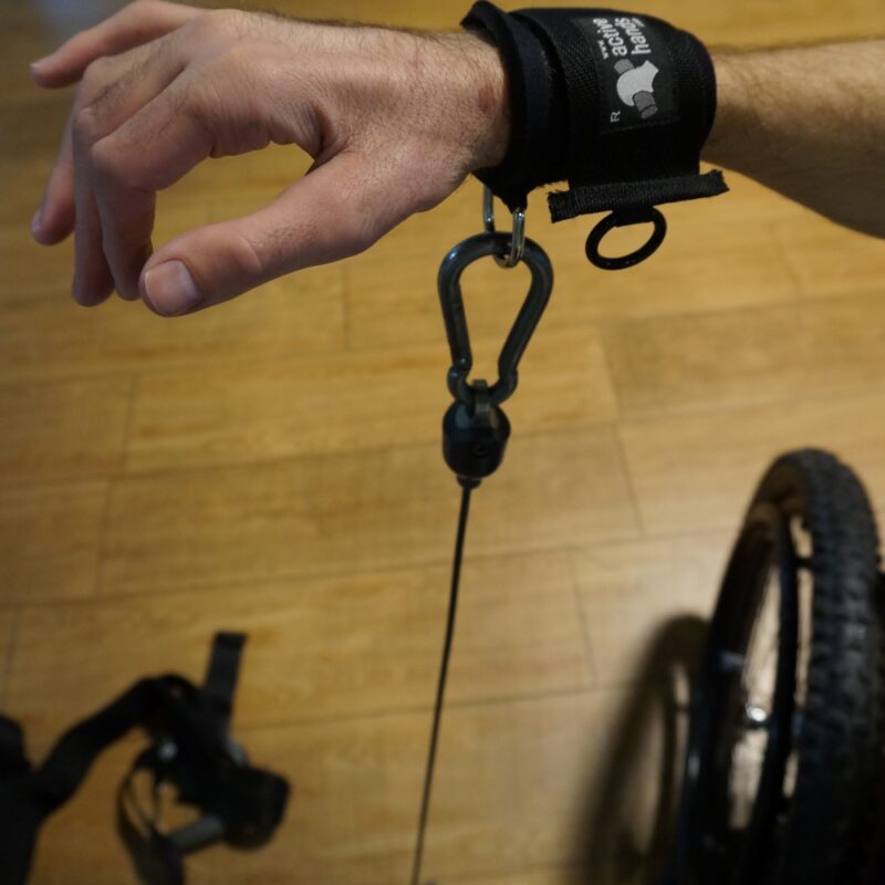 D ring shown on wrist strap attached to a caribiner attached to a resistance wheel